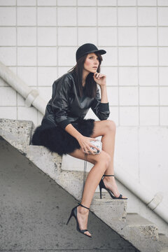 A beautiful woman sitting on a set of stairs looking away