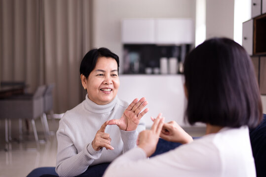 Sign Language Specialist Talking With Elderly Patient Deaf Hearing And Showing Hand Gestures