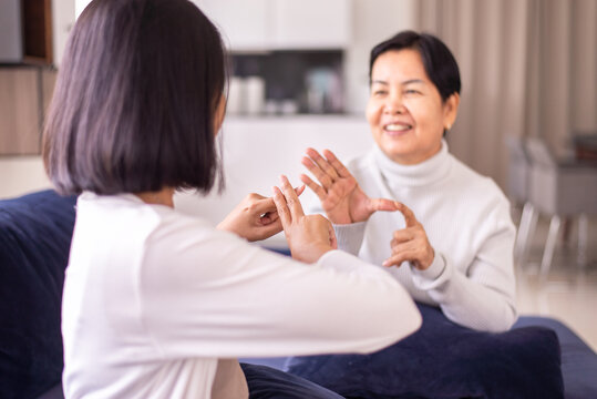 Sign language specialist talking with senior patient deaf hearing and showing hands gesture
