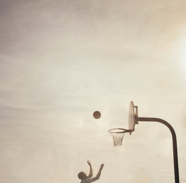 silhouette of man playing basketball