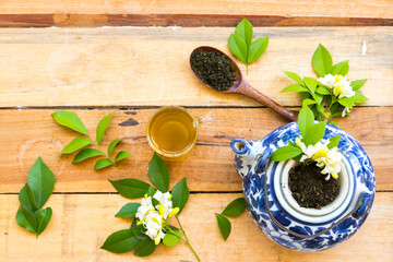 herbal healthy drinks hot green tea with mashed leaf tea in wooden spoon and flower jasmine for...