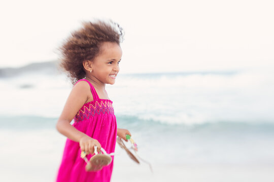 Young girl in pink playing on the beach