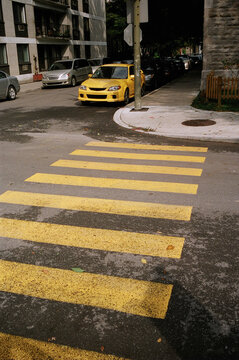 A yellow car matches the crosswalk