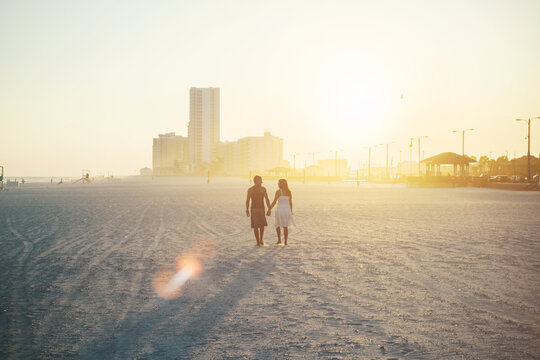 Couple walking on beach holding hands