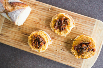 plant-based food, vegan snack with paprika hummus on sliced baguette bread topped with sundried tomatoes