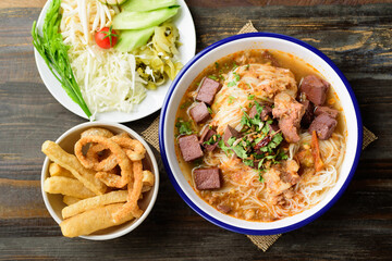 Northern Thai food (Kanom Jeen Nam Ngeaw), Rice noodles spicy soup with pork and pork blood in a bowl eating with fresh vegetables and pork rind