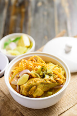 Northern Thai food (Khao Soi), Spicy curry noodles soup with chicken in a bowl, Local Thai food