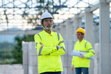 Construction manager and engineer working on construction site.