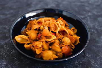 plant-based food, vegan red pesto pasta with eggplant zucchini and red pepper mix with spices