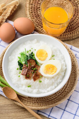 Asian breakfast food, Rice soup with boiled egg, grilled mushroom and spinach in bowl