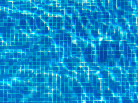 Blue Tiles on the bottom of a swimming pool on a sunny summer day