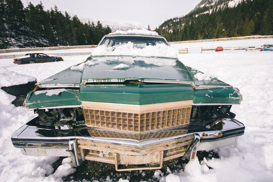 Old vintage racing car abandoned on snow junk field