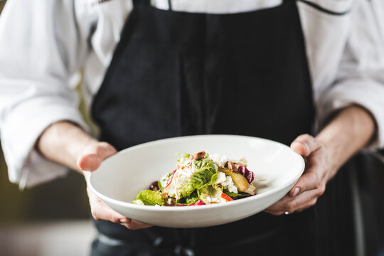 Chef holding a plate of fresh salad