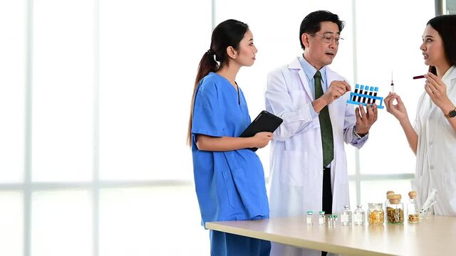Group of doctors wearing formal white coat and blue scrubs suit, Teamwork brainstorm meeting with computer laptop at the hospital. Healthcare specialist people.