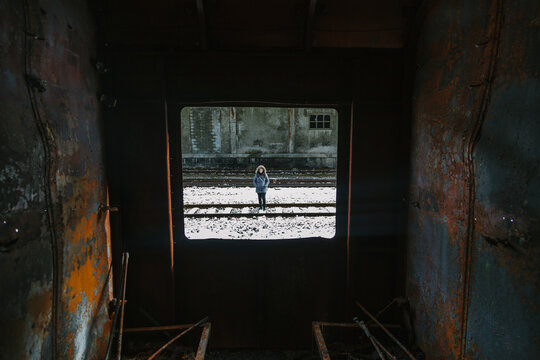 View of a Woman Through a Rusty Abandoned Train Window