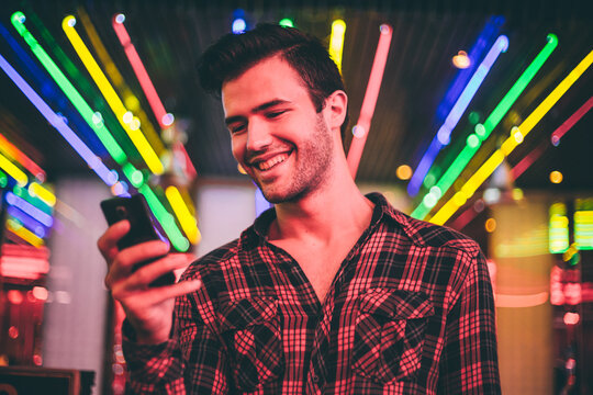 Young man checking his telephone in front of the club