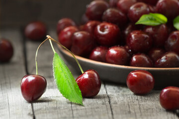 Still life with fresh cherries in a vase on the table.