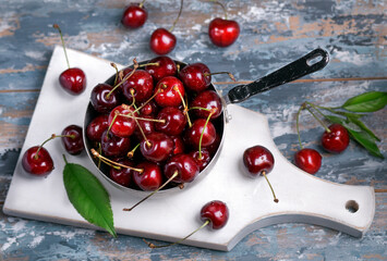 Still life with fresh cherries in a vase on the table.