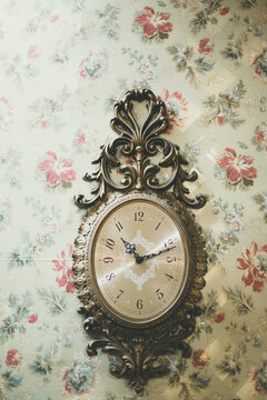 antique clock on floral wallpaper