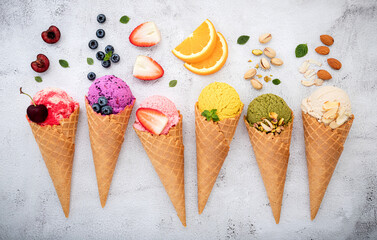 Various of ice cream flavor in cones blueberry ,pistachio ,almond ,orange and cherry setup on white stone background . Summer and Sweet menu concept.