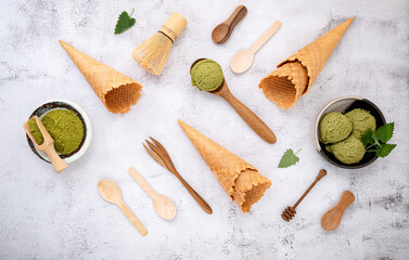 Fototapeta na wymiar Matcha green tea ice cream with waffle cone and mint leaves setup on white stone background . Summer and Sweet menu concept.