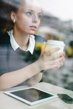 Business Woman at cafe holding a cup of coffe.