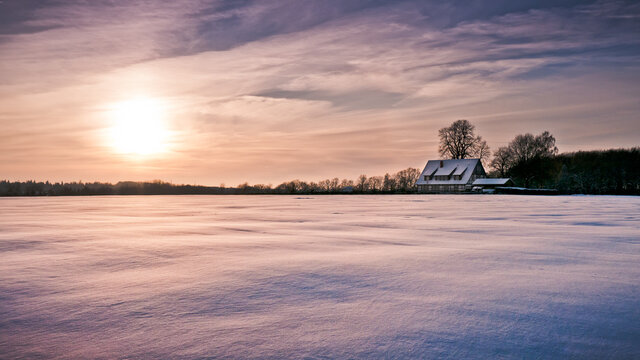 Colorful Sunrise on Snow Covered Field with Farmhouse