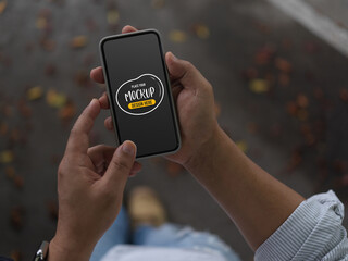 Male using mock up smartphone while walking on street