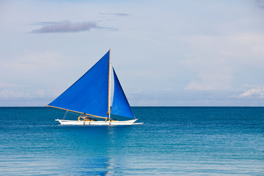 Blue sailboat on turquoise sea