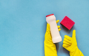 Woman's hand cleaning on a blue background.Cleaning or housekeeping concept background. Copy space. Flat lay, Top view.
