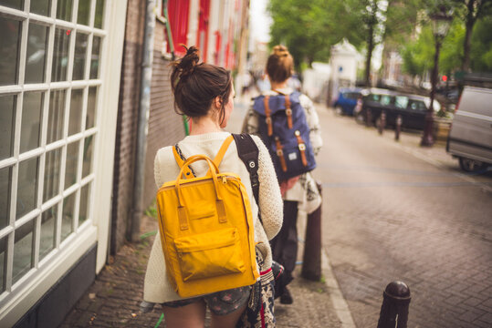 girl walking with yello backpack