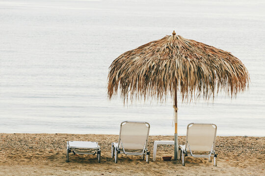 Summer straw umbrella and sunbeds on the beach