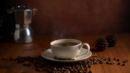 Cup of coffee and coffee pot on wooden table decorated with coffee beans