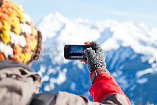 Man making a photo of mountain peaks with his phone