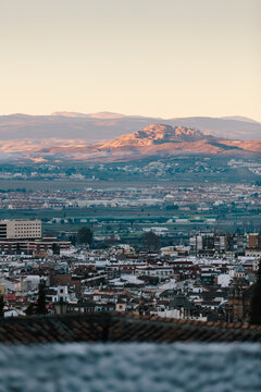 View of sunrise over city and distant mountains in Grenada Spain