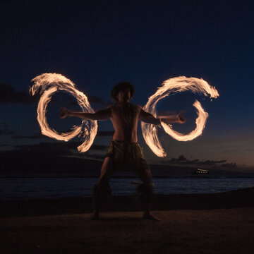 Traditional Hawaiian Fire Dancer spinning his flames into wings.