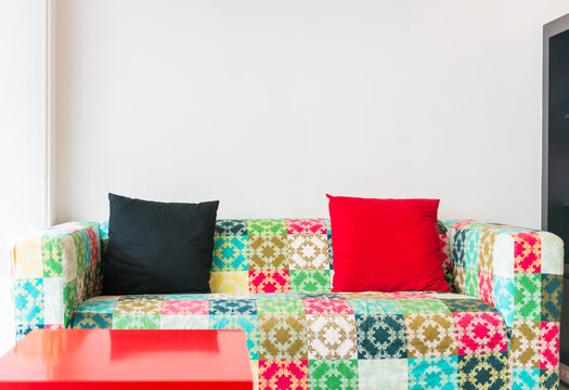 Colorful patchwork sofa with black and red cushions