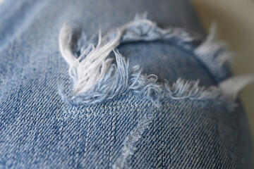 Fototapeta na wymiar Blue jeans with holes and white threads