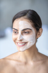 Woman applying nutritious cream to her face