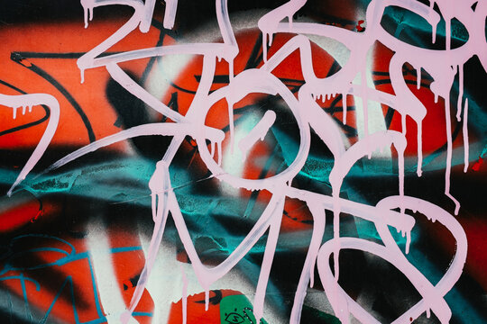 Brightly colored graffiti paint on building wall