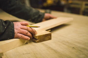 A carpenter measuring wood before working