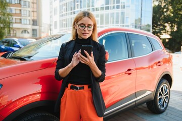 Professional female manager standing near car at office building