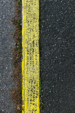 Painted yellow curb separating sidewalk and street