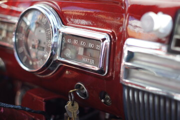 Red, shiny chrome dashboard of vintage car