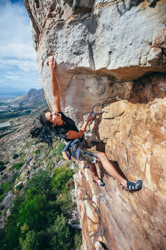Femal rock climber on climbing and extreme rock cliff in a mountain