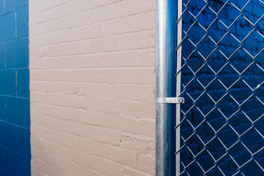 Chain-link fence in front of painted wall