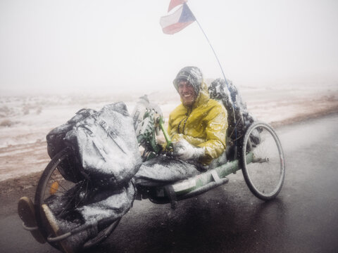Handbiker covered in snow standing on the road