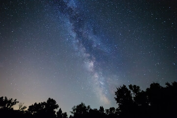 Fototapeta na wymiar forest silhouette under starry sky with milky way, beautiful night outdoor background