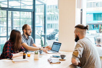 People in a business meeting at the cafe looking at laptop