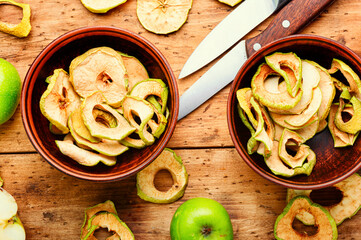 Tasty apple chips on wooden table